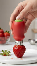 Hand pressing the strawberry huller onto a fresh strawberry