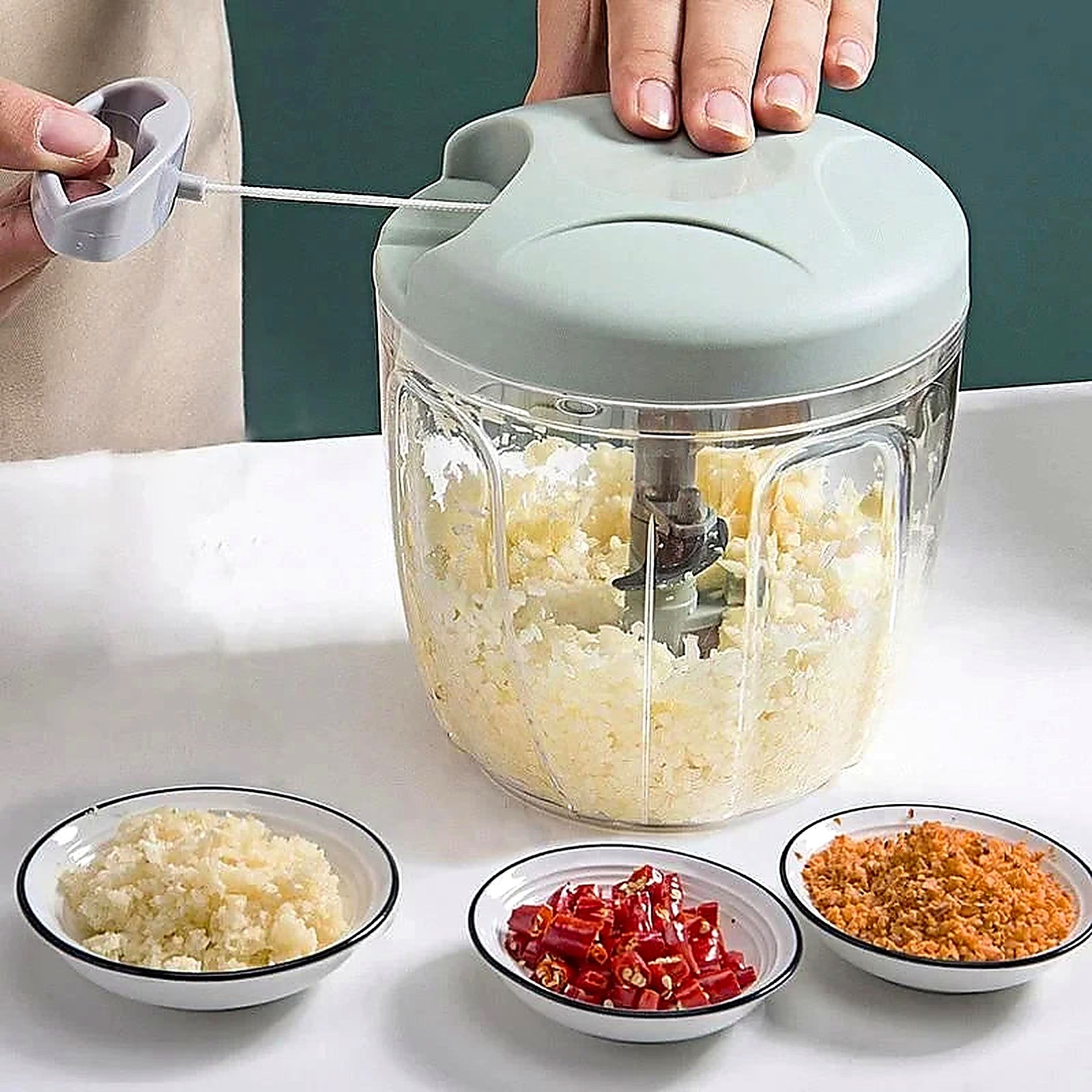 Three bowls of finely diced ingredients prepared with 12-in-1 hand chopper — peppers, garlic, herbs