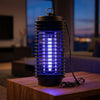 UV light on - plug-in bug zapper glowing indoors at night