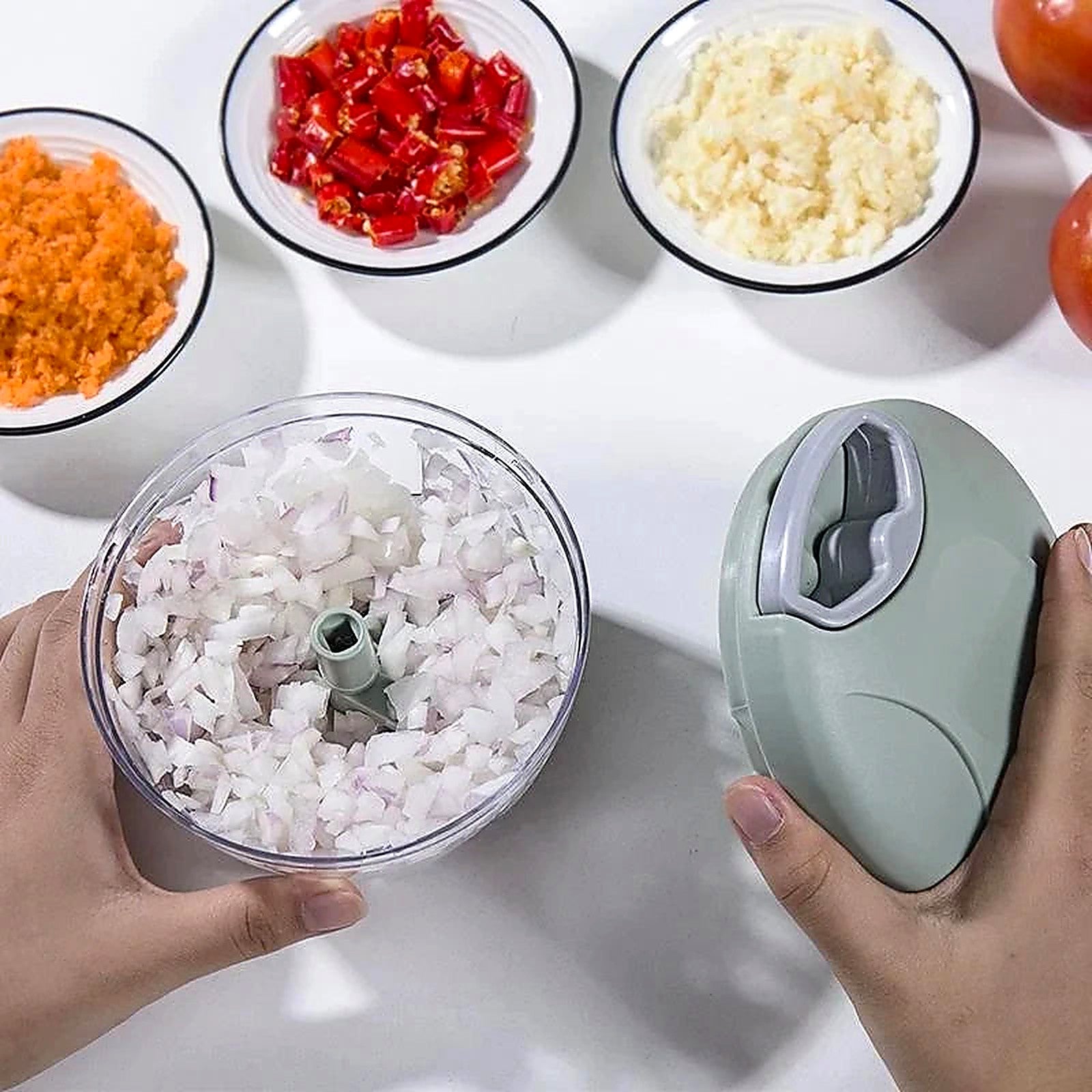 Diced onions in chopper bowl with prepped peppers, carrots and herbs — 12-in-1 manual food prep tool