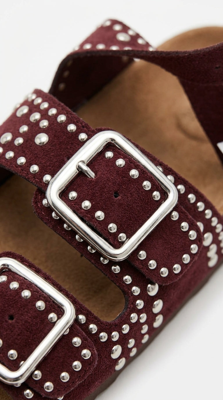 Angled pair of burgundy studded buckle sandals