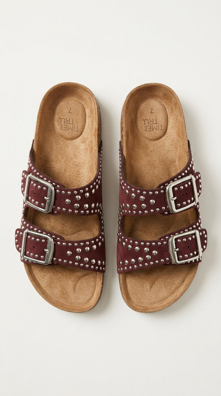 Studded footbed sandals worn on patterned tile