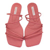 Pair of pink square toe strappy flat slide sandals on white background