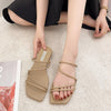 Khaki strappy flat sandals worn, seated