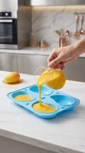 Hand pouring mousse mix into the fruit-shaped silicone mold